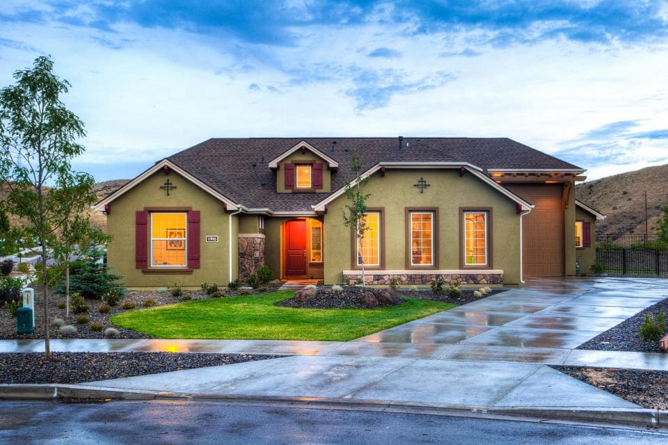 Landscaped home with healthy lawn and mulch beds at dusk